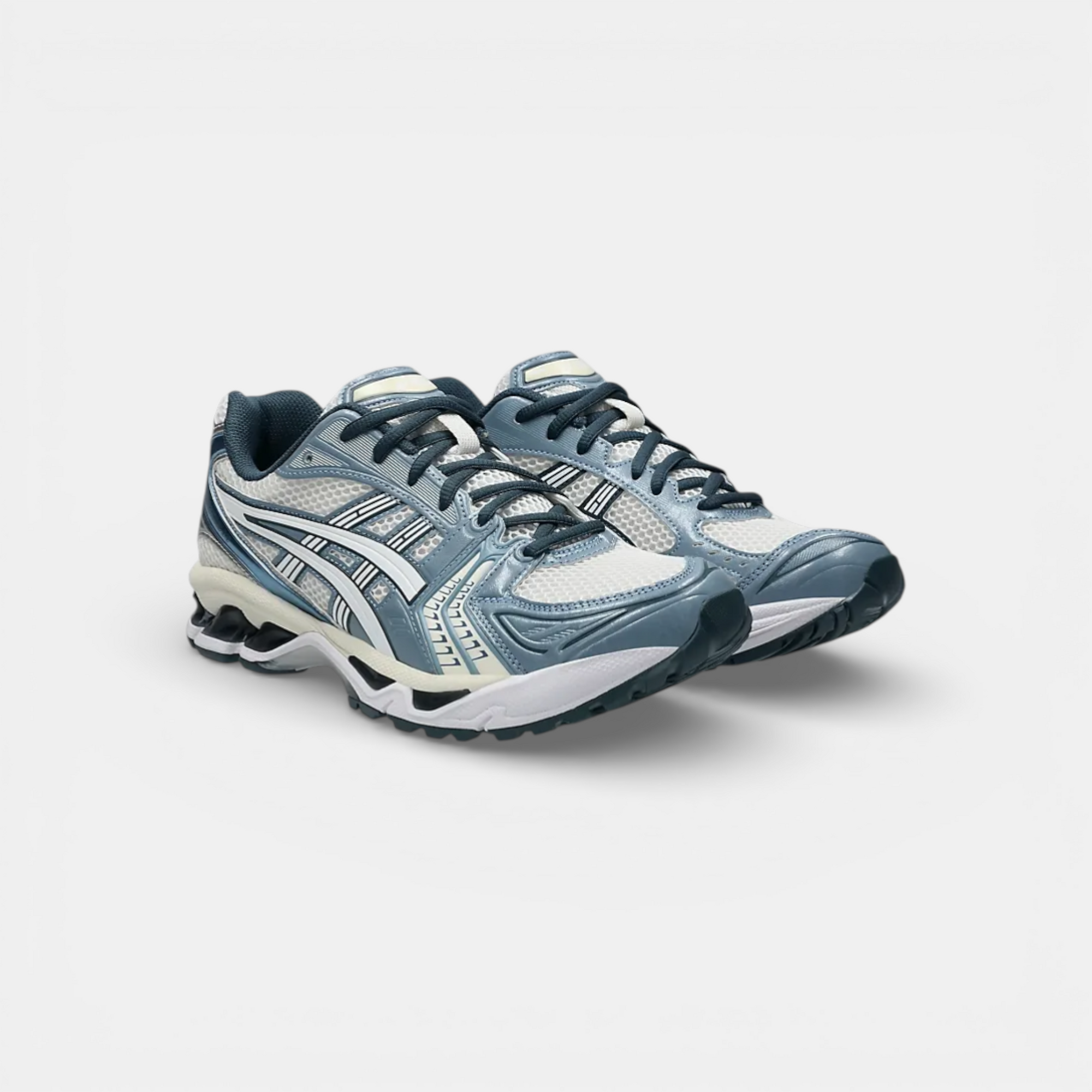 ASICS Gel-Kayano 14 running shoes in cream, white, and raw indigo. Mesh and synthetic upper with GEL cushioning and TRUSSTIC stability.